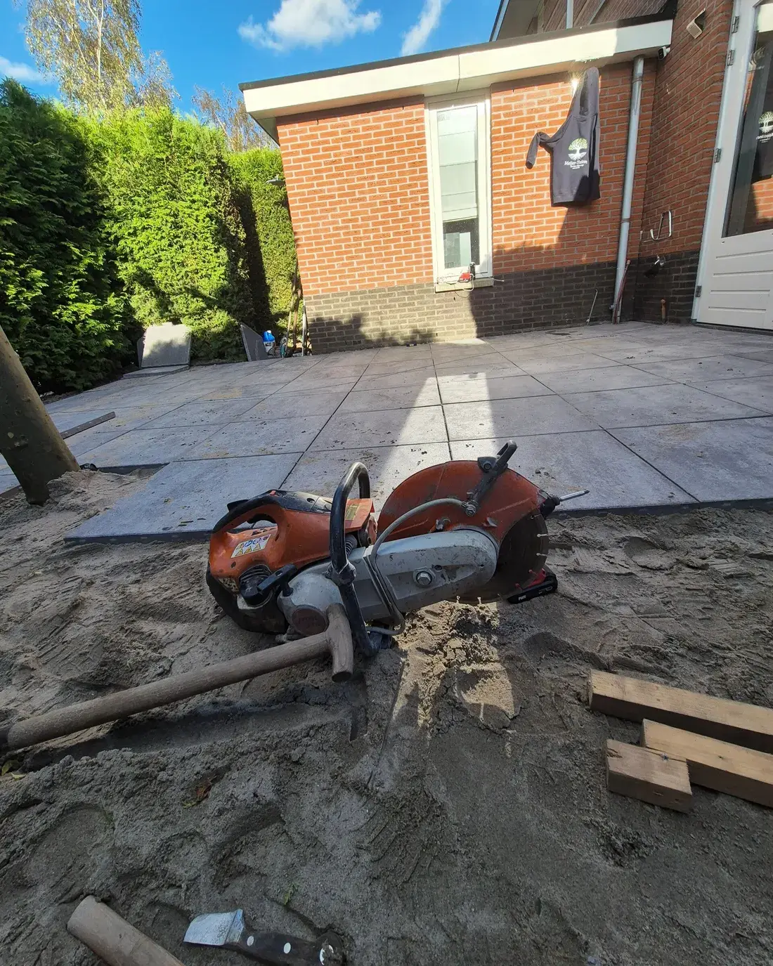Grijze grootformaat tegels op een afgereid zandbed